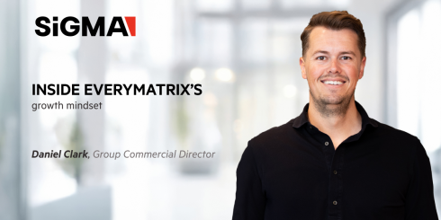 image with a blurry background of an office building, with an image of Daniel Clark on the right, SiGMA logo on the left, and the text: Inside EveryMatrix’s growth mindset